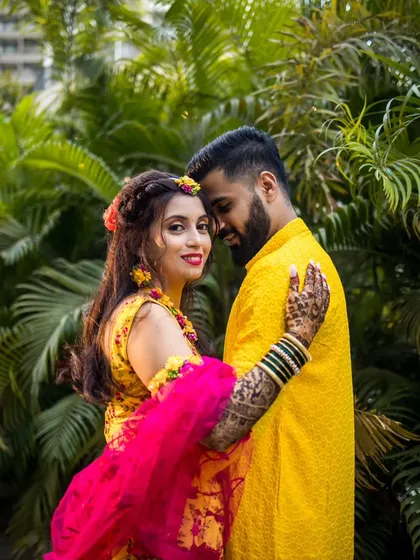 A modern and romantic couple portrait. The bride looks confidently at the camera while embraced by her partner, showcasing their connection.