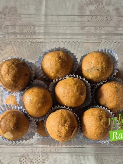 A small, convenient plastic container of Besan Laddoos, perfect for a snack or a small gift.