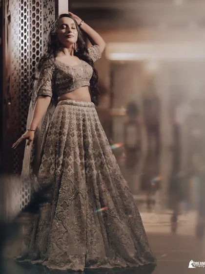 A full-length, high-fashion portrait of bride-to-be Manya, showcasing her stunning golden lehenga and confident pose.