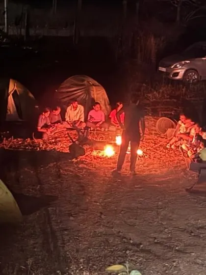 Our campsite at night, with tents pitched and trekkers gathered around a crackling campfire. This is the perfect end to a day of hiking.