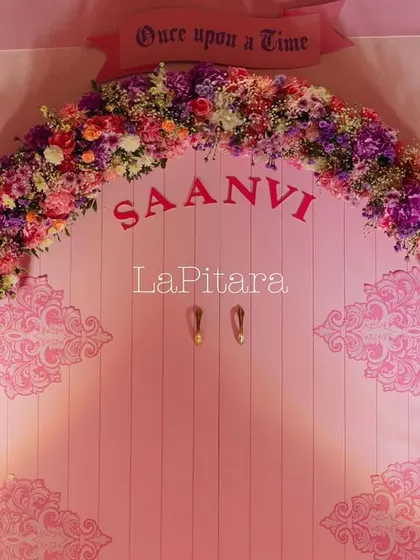 A fairytale door with a beautiful floral arch, personalized with the birthday girl's name. This serves as a perfect photo backdrop.