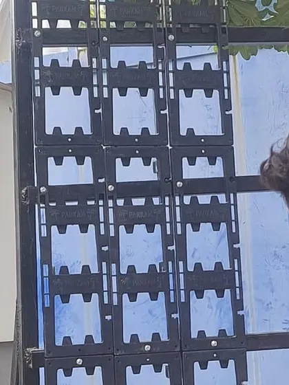 A team member installs the interlocking modular panels onto the MS frame. These panels are the backbone of the green wall, holding the soil and plants in place.