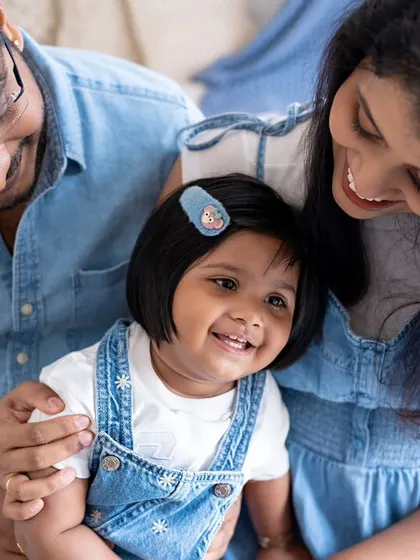 A close-up of a family sharing a happy moment. The daughter's bright smile and the parents' loving expressions make this a beautiful and intimate photo.
