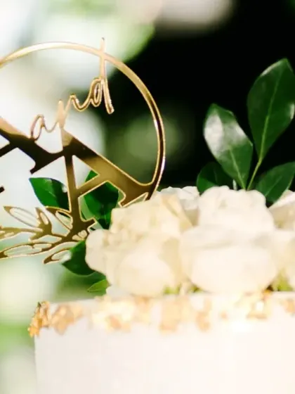 The cake cutting ceremony is a classic moment. We designed this elegant cake station with a minimalist white floral backdrop, ensuring the focus remained on the couple's happy celebration.