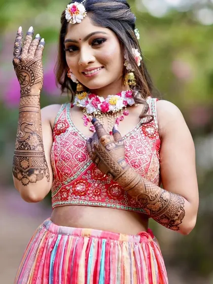 A happy bride showing her palms, which are covered in our beautiful and intricate mehandi.