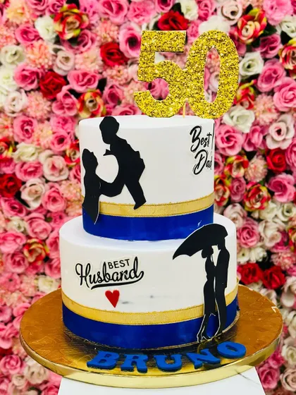 A special two-tiered cake for a 50th birthday, celebrating the 'Best Dad' and 'Best Husband'. The silhouette designs add a personal and heartfelt touch.