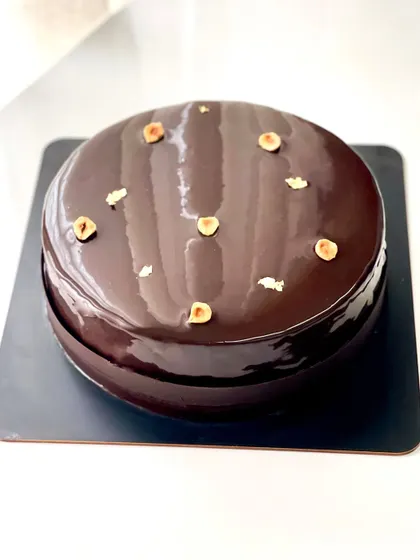 A rich and decadent entremet for a 50th birthday celebration. This one features layers of chocolate brownie, toasted hazelnut cremeux, and dark chocolate mousse, all covered in a shiny dark chocolate glaze.