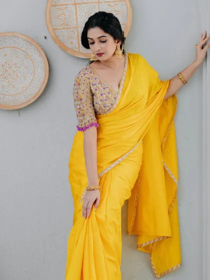 A full view of the yellow saree, showcasing its vibrant hue and the beautiful contrast with the designer blouse.