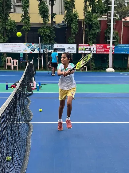 Focus and determination on display as a young player connects with the ball at the net. We cultivate a training environment where every player is engaged and working to improve.