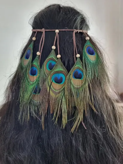 Unleash your inner bohemian goddess with our peacock feather headband. The natural iridescence of the feathers makes this a truly eye-catching hair accessory.