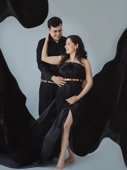 A powerful and elegant couple's portrait. The flowing black fabric creates a dramatic effect, making this a truly standout image from their maternity session.