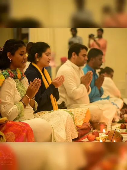 Participants offer prayers during the Guru Purnima celebration. The hall is filled with an atmosphere of devotion, creating a powerful collective experience of gratitude.