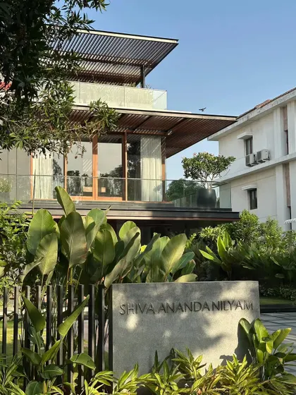 The entrance to 'Shiva Ananda Nilyam' (Villa re:FORM), where a custom concrete nameplate complements the modern, natural material palette of the renovated home.