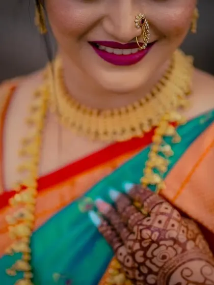 A close-up on the bride's happy smile and her stunning gold necklace, capturing the essence of bridal radiance.