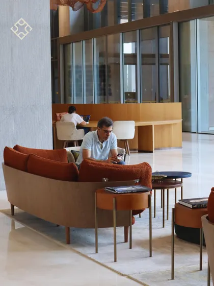 A customer working on his phone in our spacious lounge area, showcasing the different zones available for various work styles.