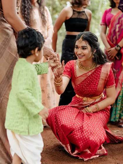 A heartwarming moment between the bride and a young guest. Her makeup is soft and approachable.
