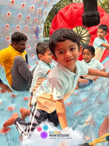 A child smiles for the camera from inside a zorb ball, fully immersed in the fun and adventure of the day.