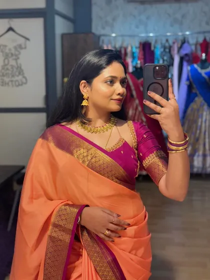 A selfie of me in a beautiful peach saree with a contrasting magenta blouse from my own collection.