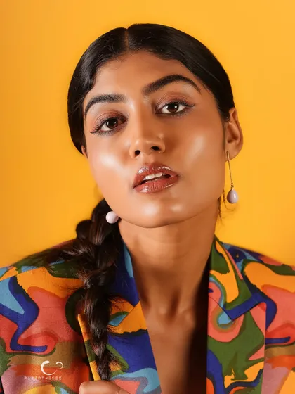 A slightly softer expression in this close-up, showing a different side of her personality while still rocking the bold, artistic suit.