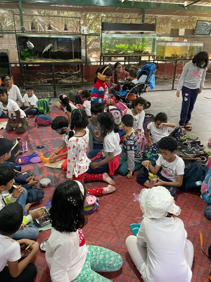 A wide view of the children resting and having a snack at the animal sanctuary. These trips are a blend of structured learning and unstructured social time.