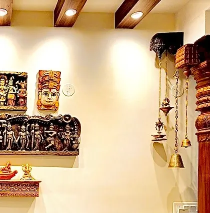 A close-up of the wall from image 206, showing the intricate details of the wooden carvings and hanging brass bells.