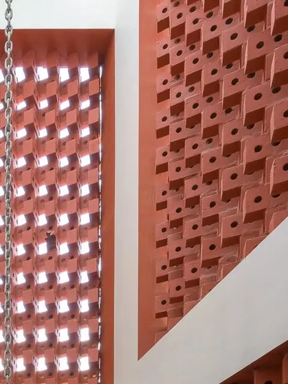 The custom-laid brick pattern creates a screen that is both functional and decorative, allowing for ventilation and privacy while casting beautiful light patterns.