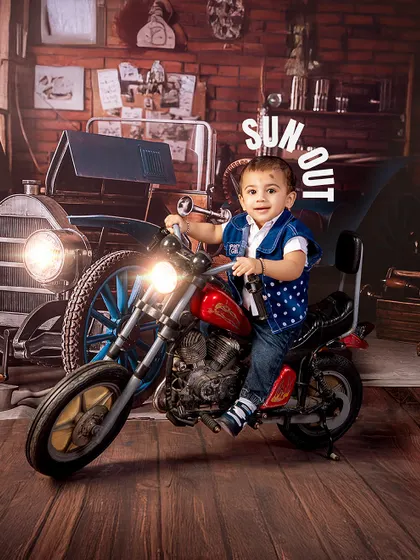 Sun's out, guns out! This little biker is ready to ride, looking cool and confident on his miniature motorcycle in the vintage garage set.