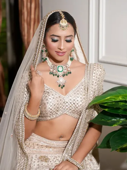A demure bridal pose. The soft makeup and sleek hair bun create a look of pure elegance and sophistication.