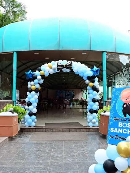 A welcoming balloon arch and sign for a Boss Baby first birthday party at an outdoor venue, setting a fun and festive tone right from the entrance.