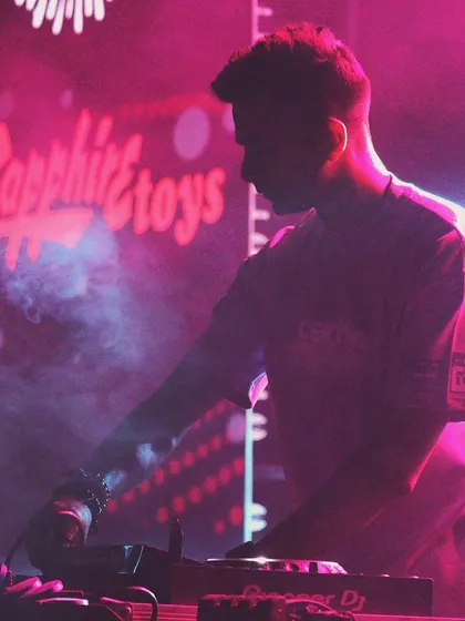 A duplicate of 58, this atmospheric shot captures me in the zone, surrounded by smoke and pink lighting at the college event.