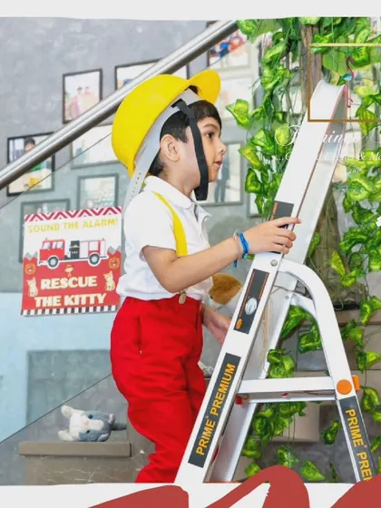 A young guest enjoying the 'rescue the kitty' ladder-climbing activity, part of the immersive firefighter training experience.