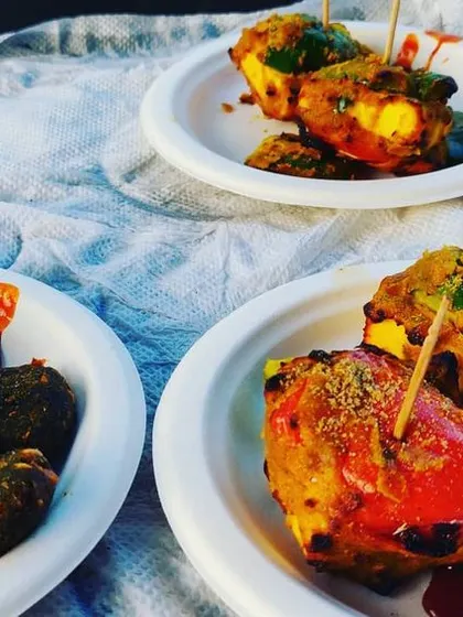 Plated tandoori appetizers, including paneer tikka and hara bhara kabab, served with mint chutney for a perfect start to the meal.