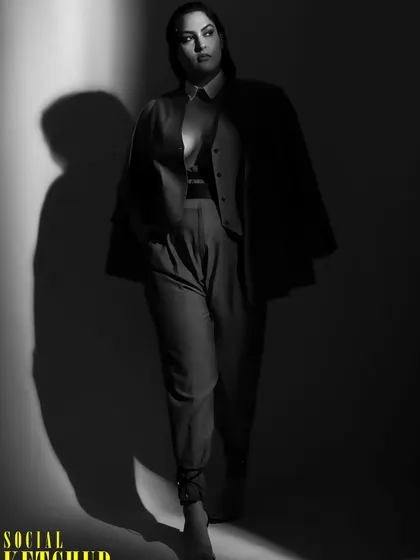 The play of light and shadow in this photo adds a dramatic feel to the power suit. This is an example of how professional styling for a photoshoot considers lighting and mood.