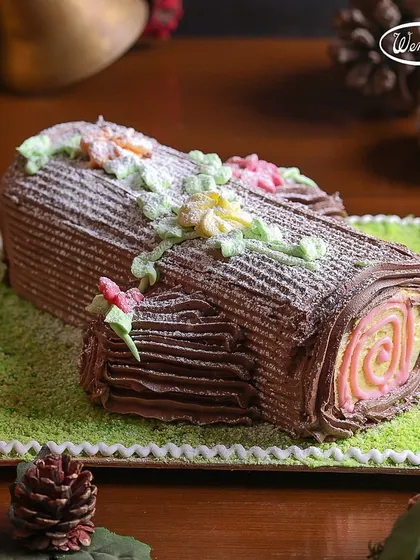 Our Yule Log cake is a festive work of art. This one features a colourful swirl inside and is decorated with delicate, handcrafted sugar flowers, bringing a touch of spring to a winter celebration.