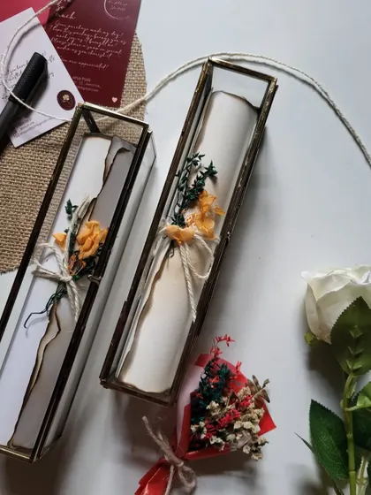 A pair of scroll letters, each adorned with a different dried flower. I can customize these details to make your gift unique.