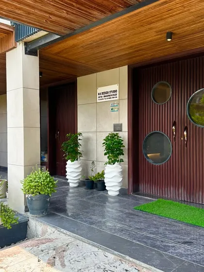 The entrance to the architect's studio, where potted plants and a simple green mat create a welcoming and grounded entryway.