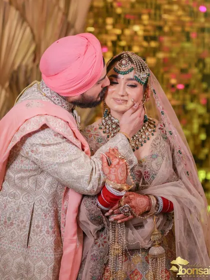 A sweet moment as the groom kisses his bride's cheek.