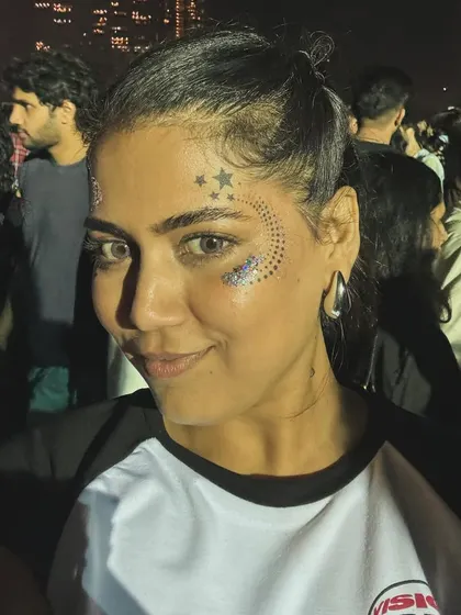 A client enjoying a concert with her cool star and glitter face art.
