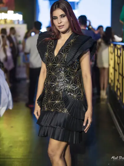 A slightly different angle of the geometric dress, highlighting the shoulder details and the model's expression.