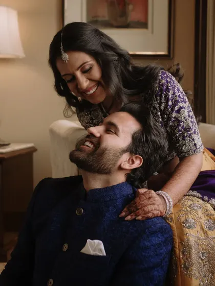 A sweet and candid moment shared between the couple during one of their functions. The genuine smiles and gentle touch make this a heartwarming photograph.
