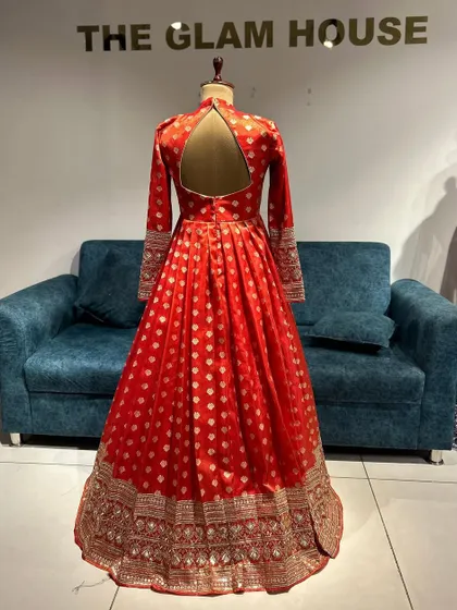 The back of a royal red Anarkali gown made from Banarasi fabric, featuring a stylish keyhole back.