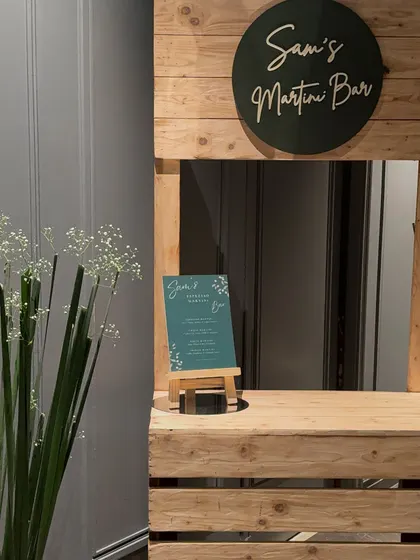 We can create custom elements like this rustic wooden martini bar. It adds a unique, interactive station for guests and reinforces the party's theme.
