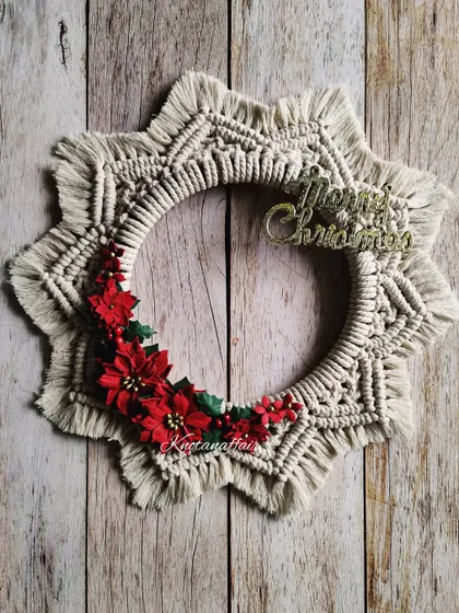 This macrame Christmas wreath, adorned with poinsettia flowers, is a perfect statement piece for your door or entryway.
