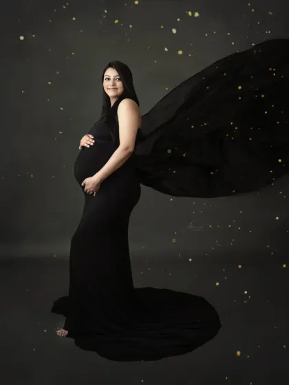 A solo portrait with a touch of sparkle. We added a magical star-like effect to this photo of a mom-to-be in a flowing black gown, creating a celestial vibe.