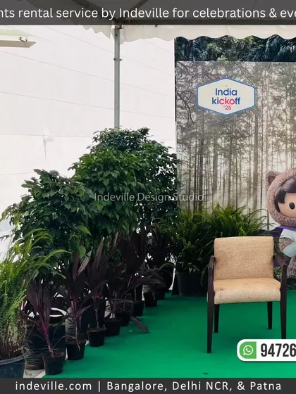 A duplicate image of the indoor photo booth, framed with lush green plants.