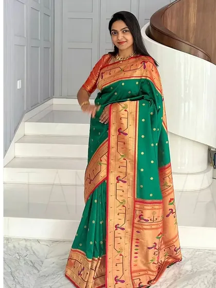 Graceful as ever, this client is wearing a beautiful Paithani saree with a custom-designed raw silk blouse in a contrasting red-orange hue.