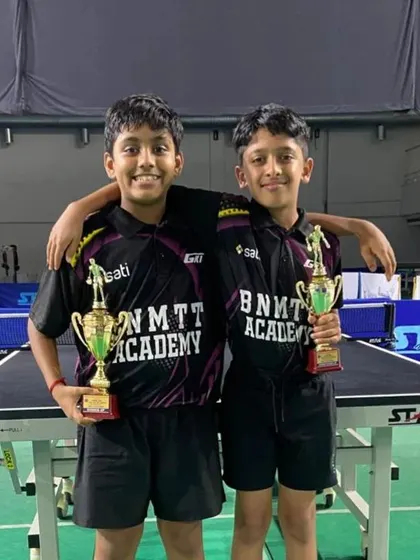 Shriram and Sudhanva, our U-13 silver and bronze medalists, posing with their trophies at the table.