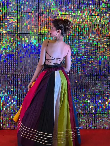 A backless choli and a twirling skirt against a shimmery backdrop. I focus on creating choreography that highlights both the dancer and their festive outfit.