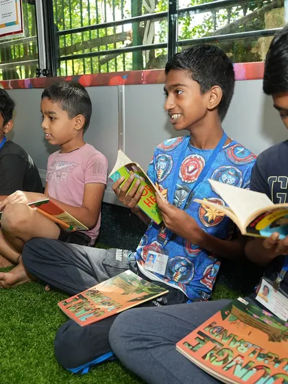 A group of boys enjoying their reading time on the comfortable turf inside the Sound Space on Wheels bus.