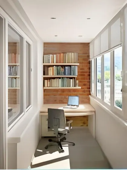 This enclosed balcony is converted into a quiet, light-filled study. The long desk provides ample workspace, while built-in bookshelves against the brick wall offer plenty of storage for a complete home office setup.